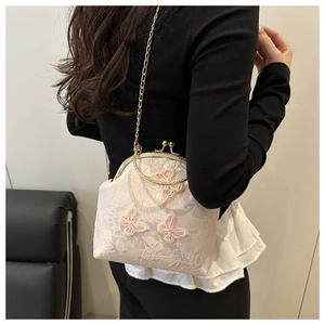 Close-up of vintage style handbag with 3D butterfly embroidery and metal top handle