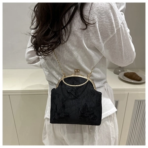 Détail du sac en dentelle noire avec broderie rétro et poignée en anneau doré