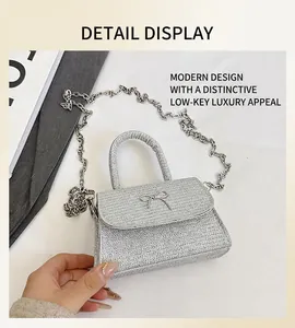 Detailed close-up of sparkling silver bow bag texture with metallic chain strap