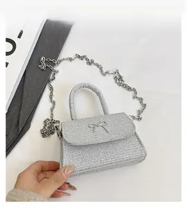 Detailed close-up of sparkling silver bow bag texture with metallic chain strap