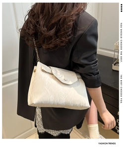 Détail du sac à bandoulière blanc cassé avec texture plissée en similicuir et chaîne