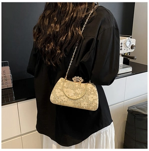 Detail of lace evening bag with sparkling rhinestones and golden crown-shaped metal clasp