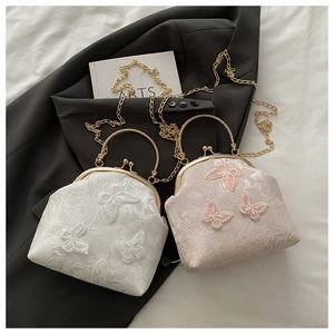 Close-up of luxury butterfly embroidery handbags with gold metal handles and chain straps
