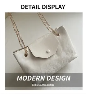 Detail of cream pleated leather texture and gold chain strap on stylish shoulder bag