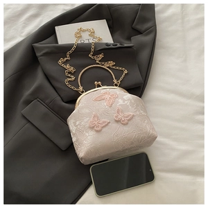 Close-up of pink jacquard frame bag with 3D butterfly appliques and gold chain strap