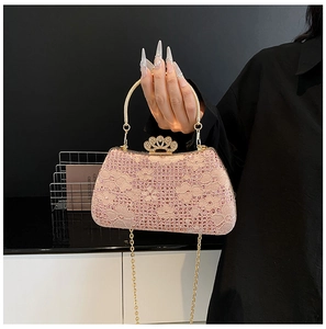 Close-up of pink lace evening bag with sparkling rhinestones and golden crown buckle