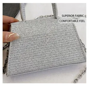 Macro shot of silver shimmering textured crossbody bag with chain strap and top handle