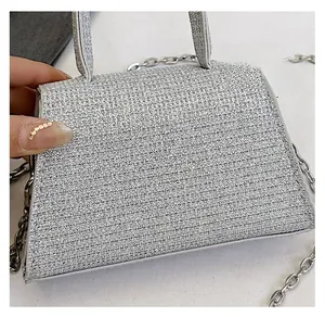 Macro shot of silver shimmering textured crossbody bag with chain strap and top handle