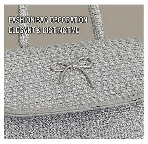 Detail of silver glitter crossbody bag with metallic bow clasp and textured surface