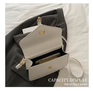 Interior view showing the capacity of the white flap bag with phone and wallet