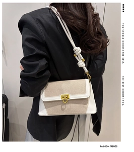 Détail du sac bandoulière tendance en toile beige et cuir blanc avec fermoir doré chic