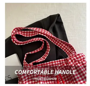 Close-up of the red and white checkered fabric handle and texture of a tote bag