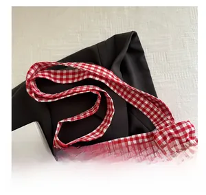 Close-up of the red and white checkered fabric handle and texture of a tote bag