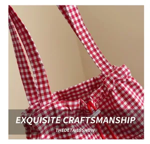 Detailed view of red and white gingham canvas tote bag with reinforced stitching and ruffle edges