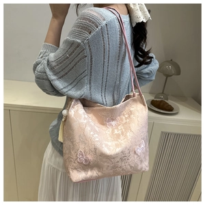 Detail of pink lace tote bag with floral embroidery and delicate butterfly appliques