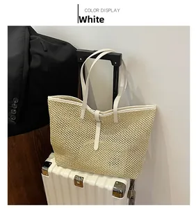 Detail of white woven straw tote bag featuring leather handles on a suitcase