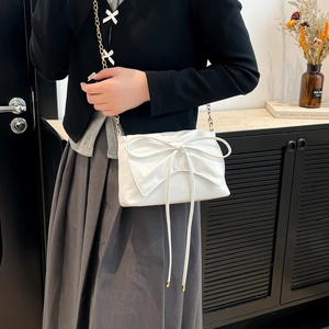 Elegant white crossbody bag with large bow decoration and gold chain strap for women