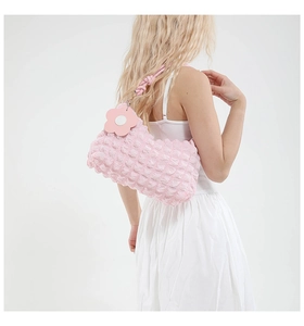 Detail of pink bubble texture shoulder bag with floral charm on model's shoulder