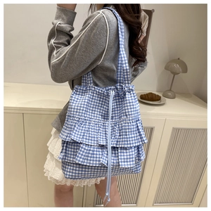 Detail of blue plaid tote bag with triple-layered ruffles and drawstring closure