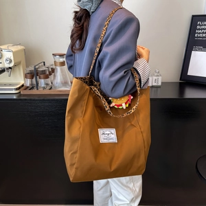 Borsa tote in tela marrone con tracolla leopardata e ciondolo a forma di hamburger