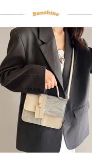 Détail du sac bicolore en cuir crème et texture argentée avec poignée supérieure