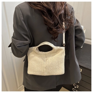 Detailed close-up of woven cream tote bag showing texture and adjustable strap