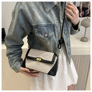 Détail du sac bandoulière en toile et cuir vintage avec fermoir rotatif doré en métal