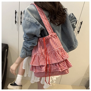 Detail of red and white checkered tote bag with triple-layered ruffles and red drawstrings