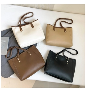Four colors of minimalist PU leather tote bags arranged on a soft fabric background