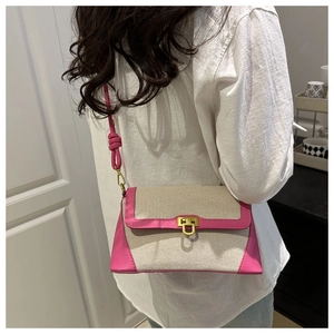 Détail du sac bandoulière en toile rose et beige avec un fermoir en métal doré