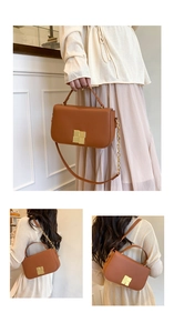 Détail d'un sac bandoulière en cuir marron avec boucle dorée et bandoulière chaîne