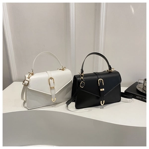 Detail of minimalist flap bags with gold U-shaped hardware and adjustable straps