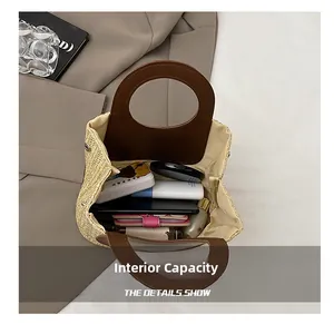 Detailed top view of a woven straw tote bag showing internal capacity and leather handles