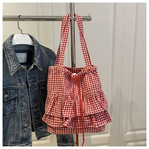 Detail of red and white checkered canvas tote bag with ruffled layers and drawstring closure