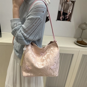 Pink lace tote bag with butterfly embroidery and bead tassel shown on female model
