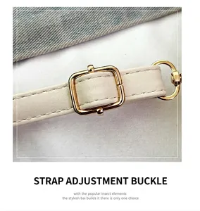 Détail de la bandoulière en cuir blanc avec boucle de réglage en métal doré et couture