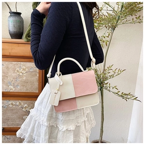Détail du sac à main bicolore rose et crème avec étiquette mode et bandoulière fine