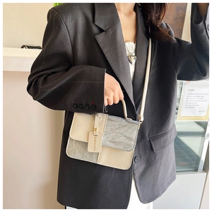 Détail d'un sac bandoulière minimaliste au design patchwork crème et argent plissé