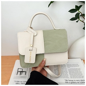 Détail des coutures contrastées et de l'étiquette FASHION BAGS sur le sac bicolore