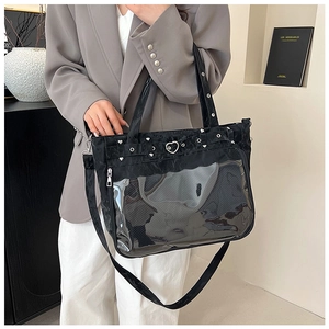 Detail of black ita bag featuring a heart-shaped buckle and transparent display window
