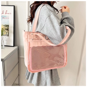 Pink canvas ita bag with mesh transparent window shown being worn by a model