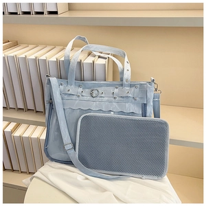 Close-up of light blue ita bag with heart-shaped metal buckle and mesh pouch