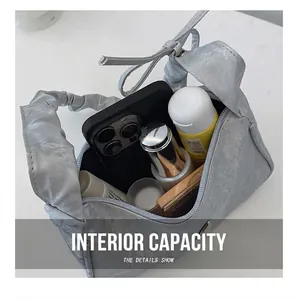 Interior capacity detail of grey shoulder bag with phone and cosmetics