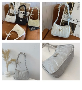 Detail of trendy French shoulder bag with metallic butterfly buckle and ruffled strap