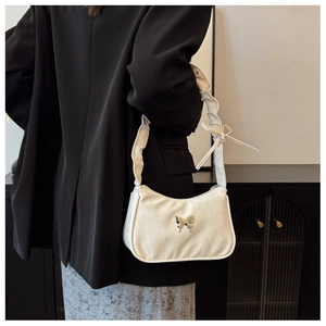 Detail of off-white hobo bag with silver butterfly buckle and ruched shoulder strap