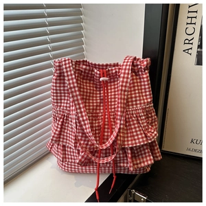 Detail of red and white gingham tote bag with ruffled design and drawstring closure