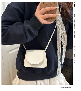 Chic white pebble leather crossbody bag styled on model with a minimalist summer look