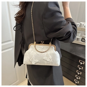Detailed shot of white lace embroidery evening bag with 3D butterfly and gold chain