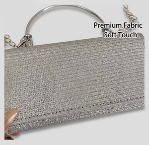 Close-up of sparkling silver sequin clutch bag with metallic ring handle and fine chain