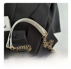 Detail of elegant white leather shoulder strap with bold golden chain rings